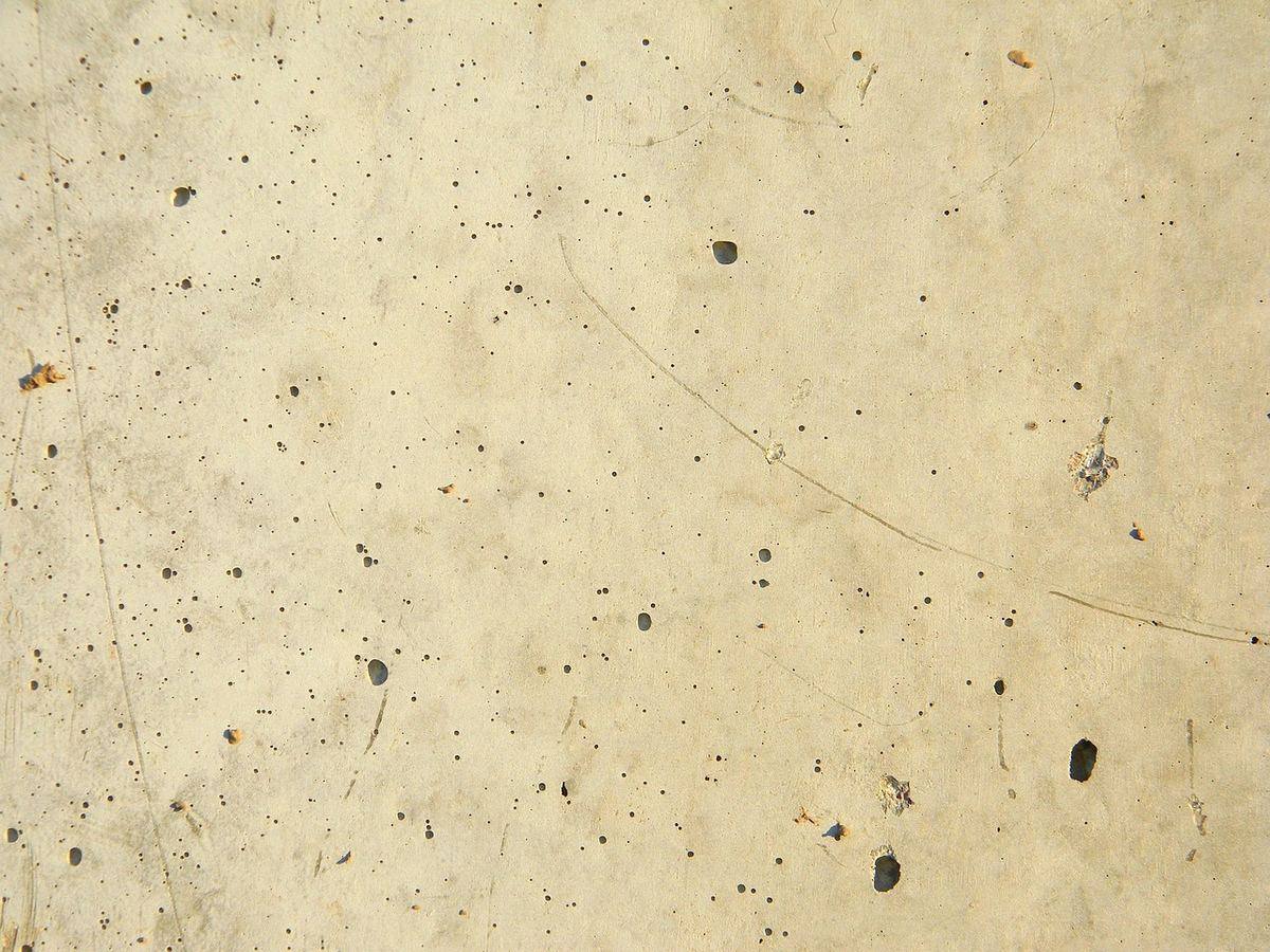 Raw concrete slab that needs grinding and prep before an epoxy coating